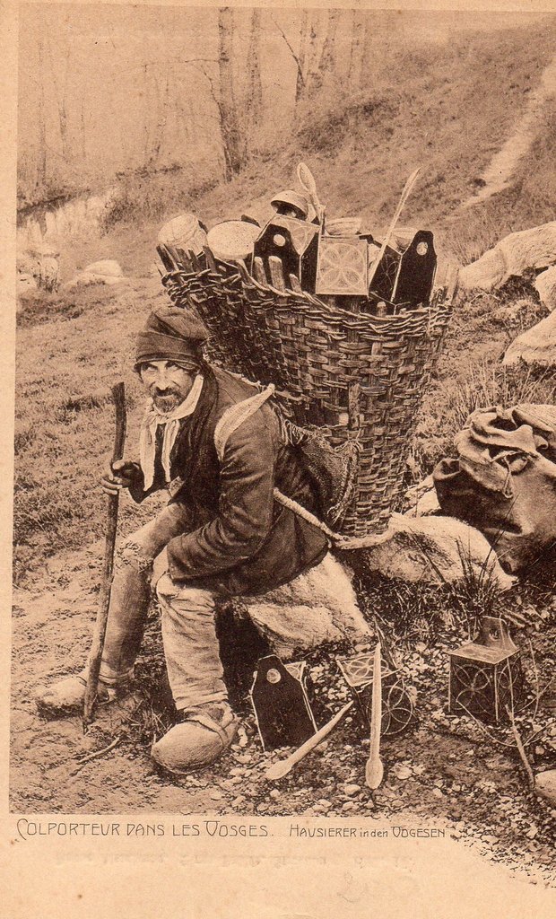 Venditore ambulante e la sua gerla dal contenuto eteroclito, nei Vosgi, cartolina, 1925