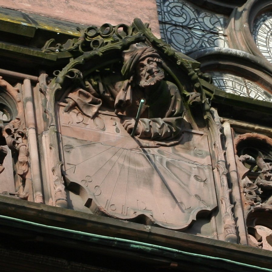 Meridiana a stilo polare della cattedrale di Strasburgo. L'avambraccio sinistro del personaggio appoggiato sul piano della meridiana tiene (teneva) nella mano lo stilo